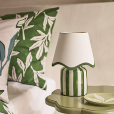 Green & White Stripe Battery Scallop Shade Lamp on a soft green scalloped side table.