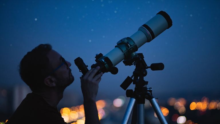person looking at the stars with a telescope