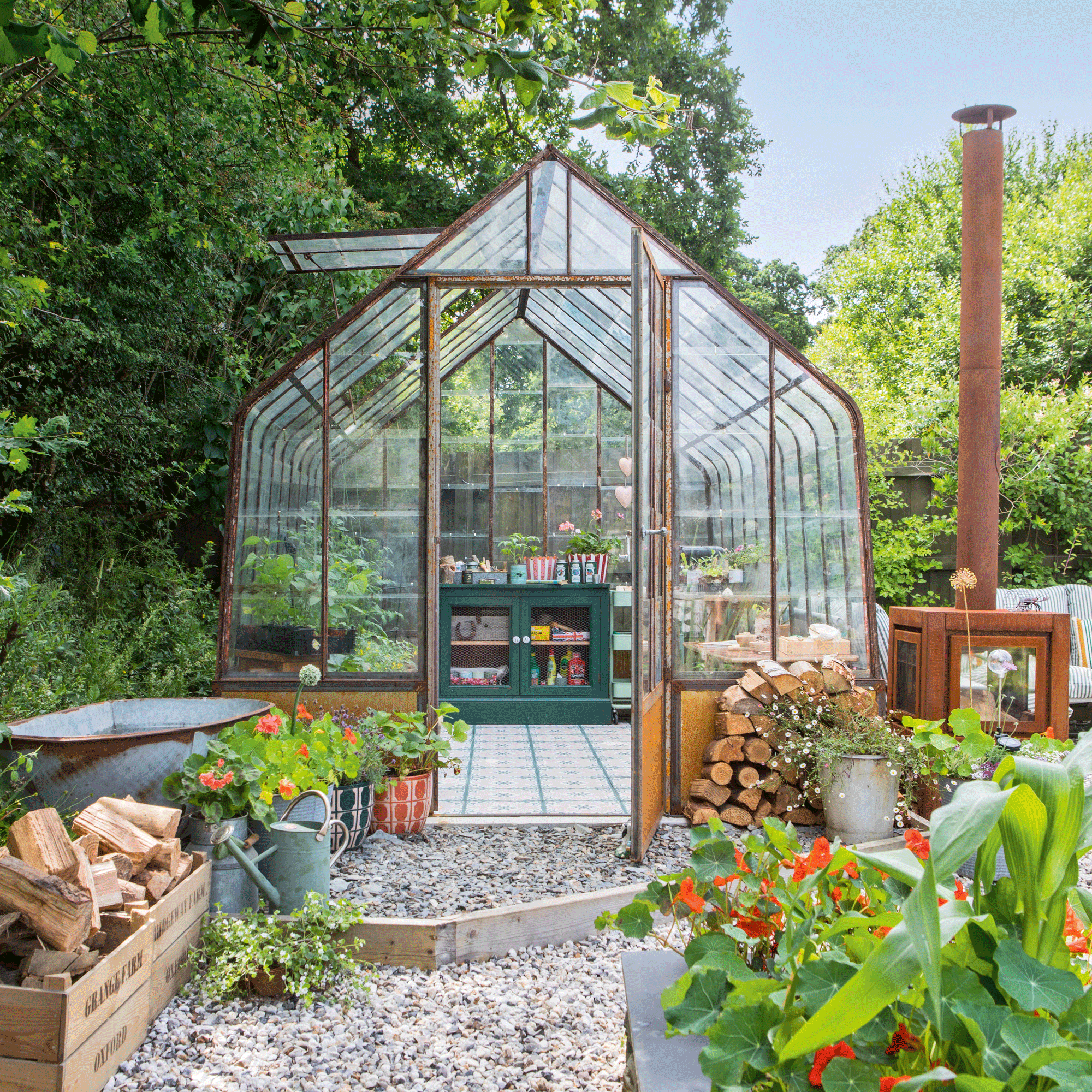 the exterior of a greenhouse with a patterned tiled floor and raised beds in the foreground