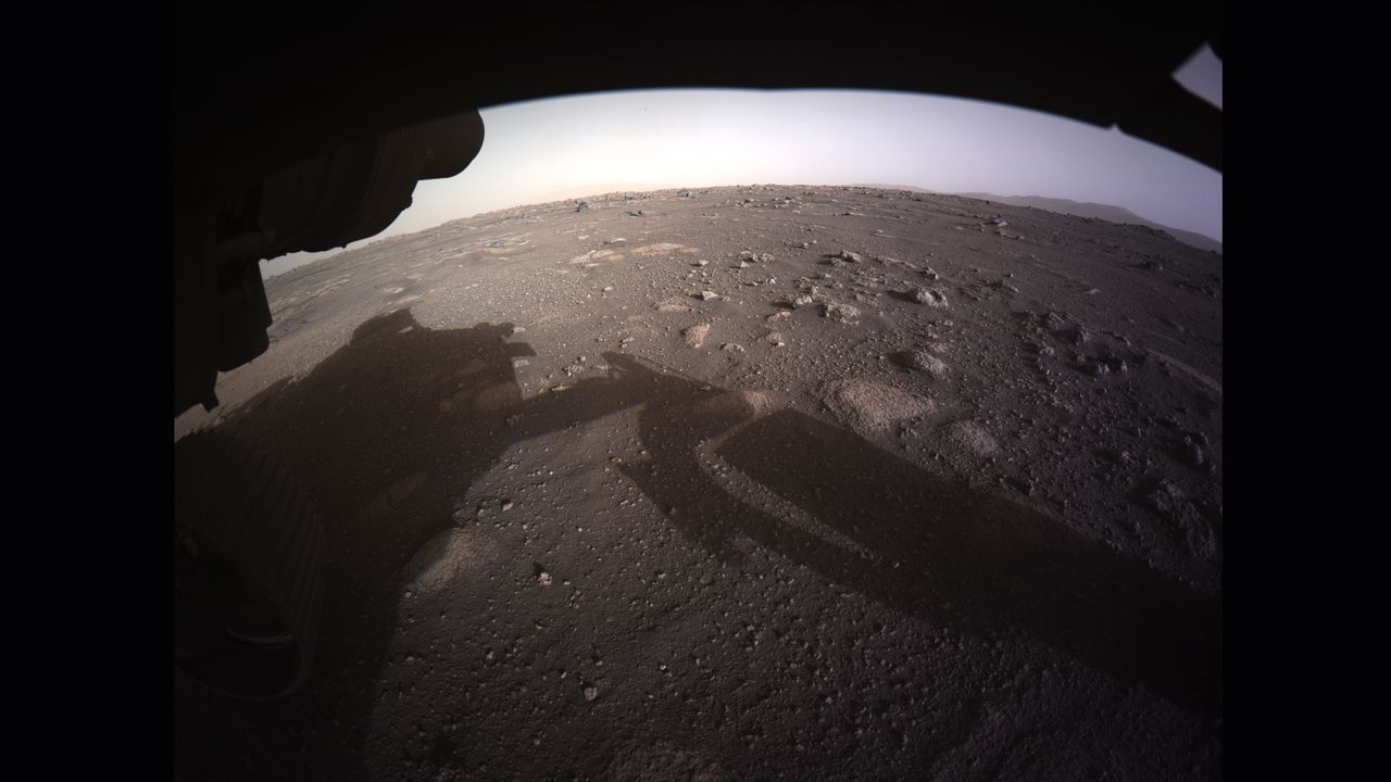Perseverance sent back the first images of its new home in Jezero Crater just minutes after landing on Mars. Perseverance is equipped with six Hazard Detection Cameras, called HazCams, located on the front and rear of the rover. The rover&rsquo;s HazCams captured this high-resolution, color image on Feb. 18, showing the rocky surface of Mars and the rover&rsquo;s own shadow cast on the Martian surface. As Perseverance continues to explore Jezero Crater, the HazCams will help the rover navigate the hazardous Martian terrain by detecting large rocks, trenches or sand dunes in its path.