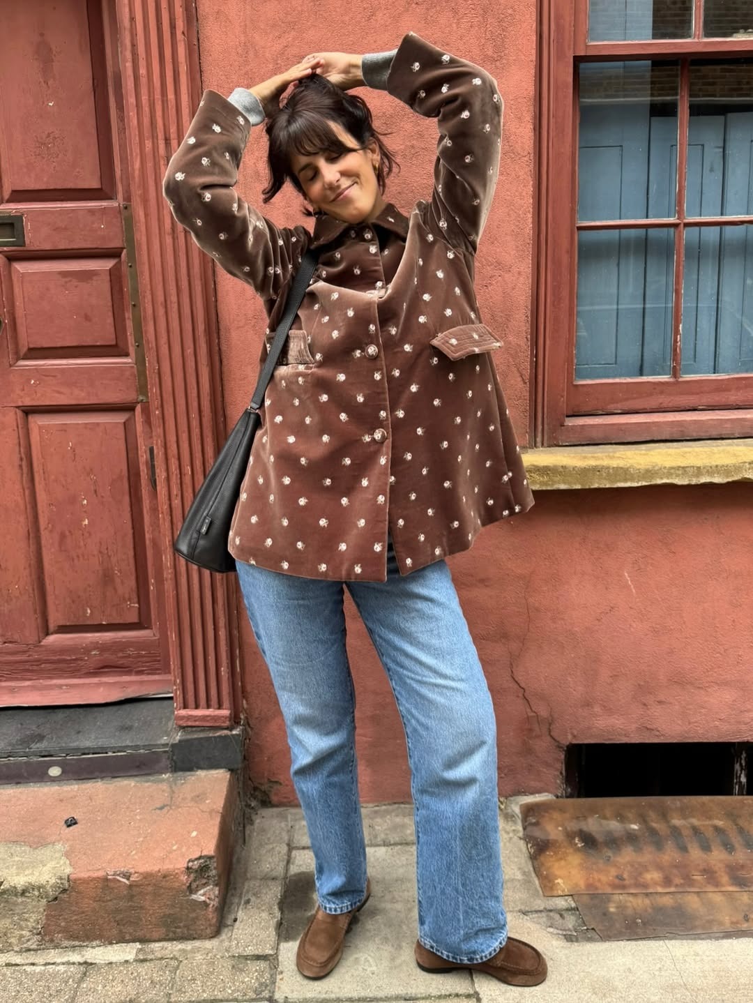 Diane Kari wearing a brown polka dot jacket with jeans.