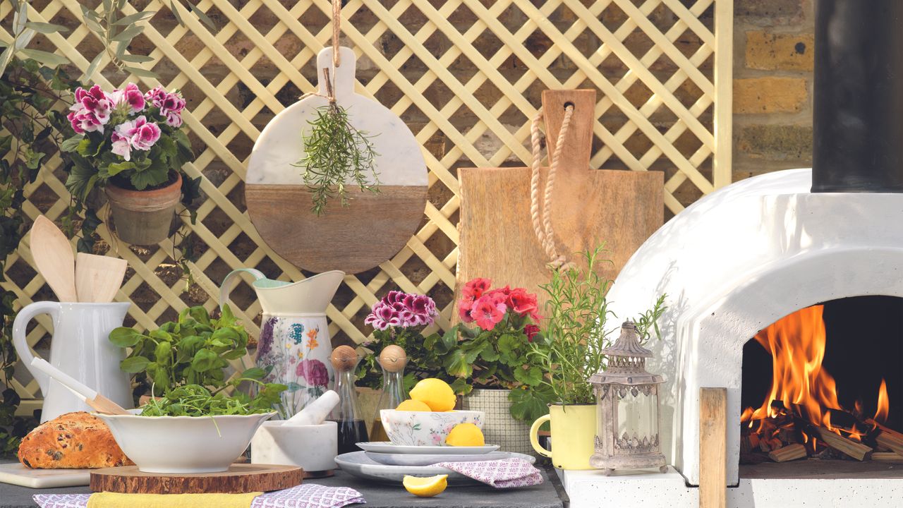 Garden with trellis behind cooking area with pizza oven