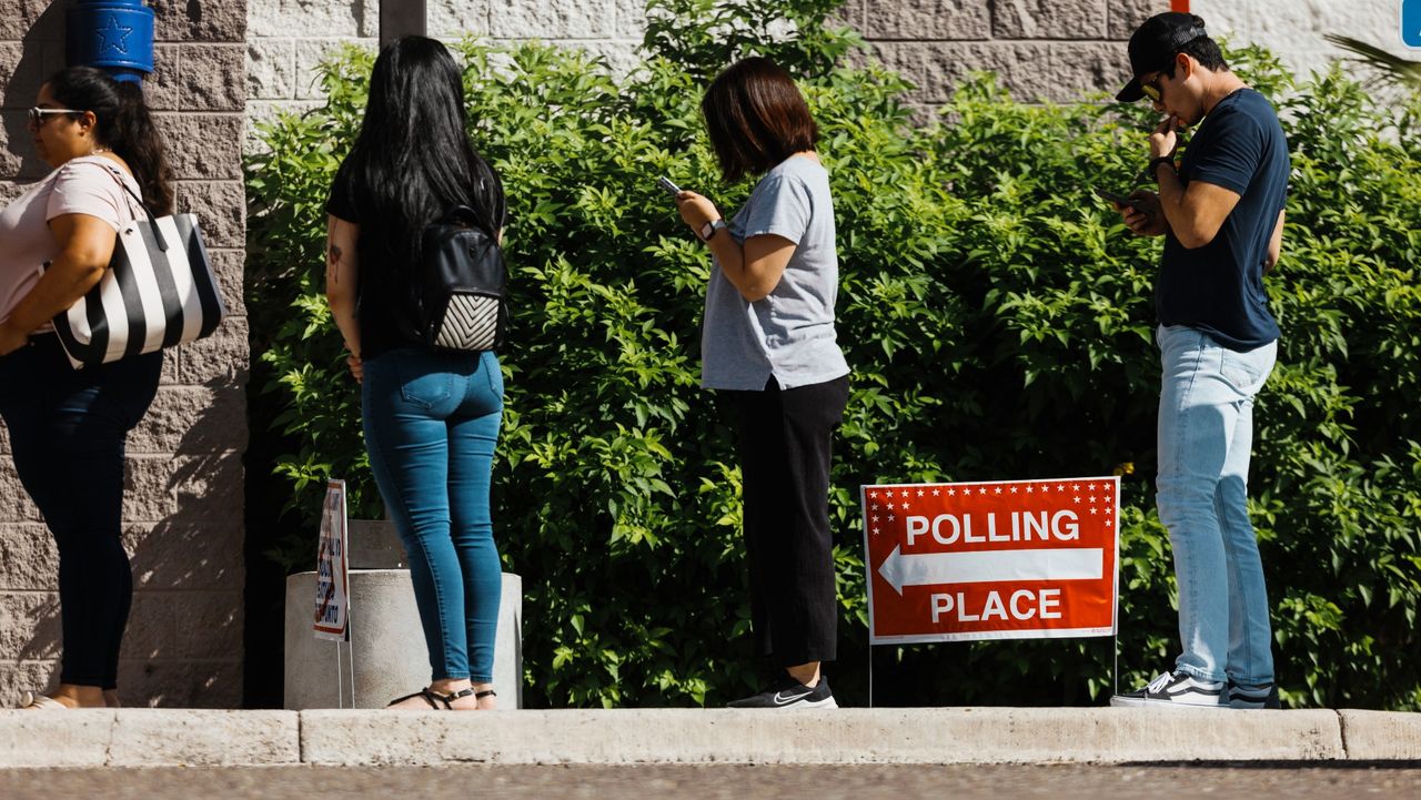 Voters wait in line outside a polling station in Texas