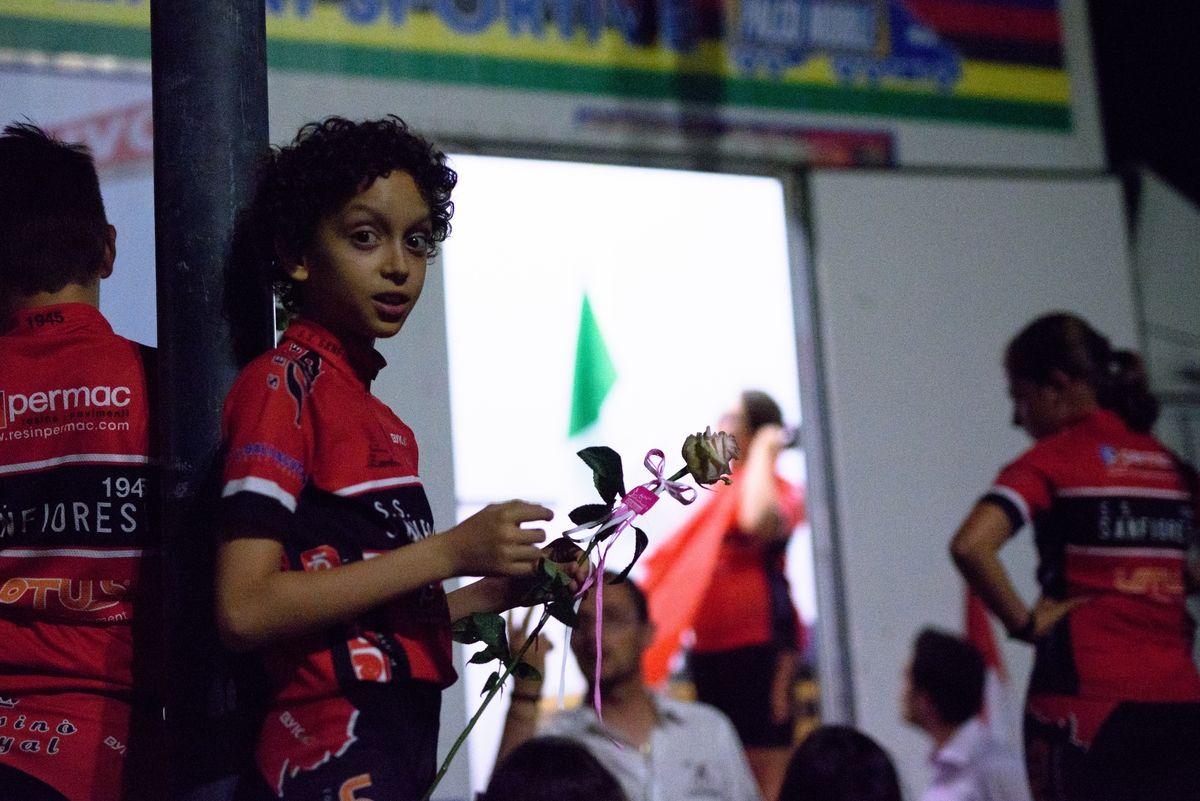 A flower bearer waits to be called onto the podium