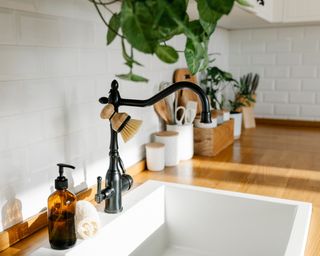 White ceramic sink in kitchen with wooden counters and a black or dark gray faucet