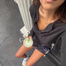 Photo of a woman wearing workout clothes sitting on steps outside 