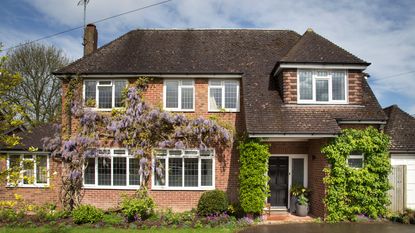 Detached red brick house with wisteria