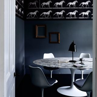 marble dining table with navy wall and wall frame