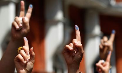 Iranian nationals show off their inked fingers after voting in the Iranian presidential election at the Iranian Consulate in London, June 14.
