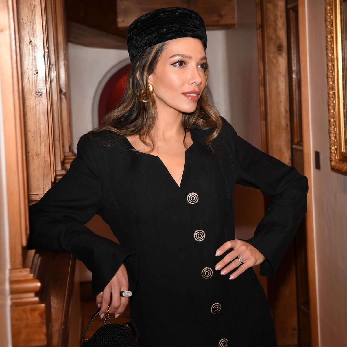leila kashanipour wears a black pillbox hat and elegant jacket