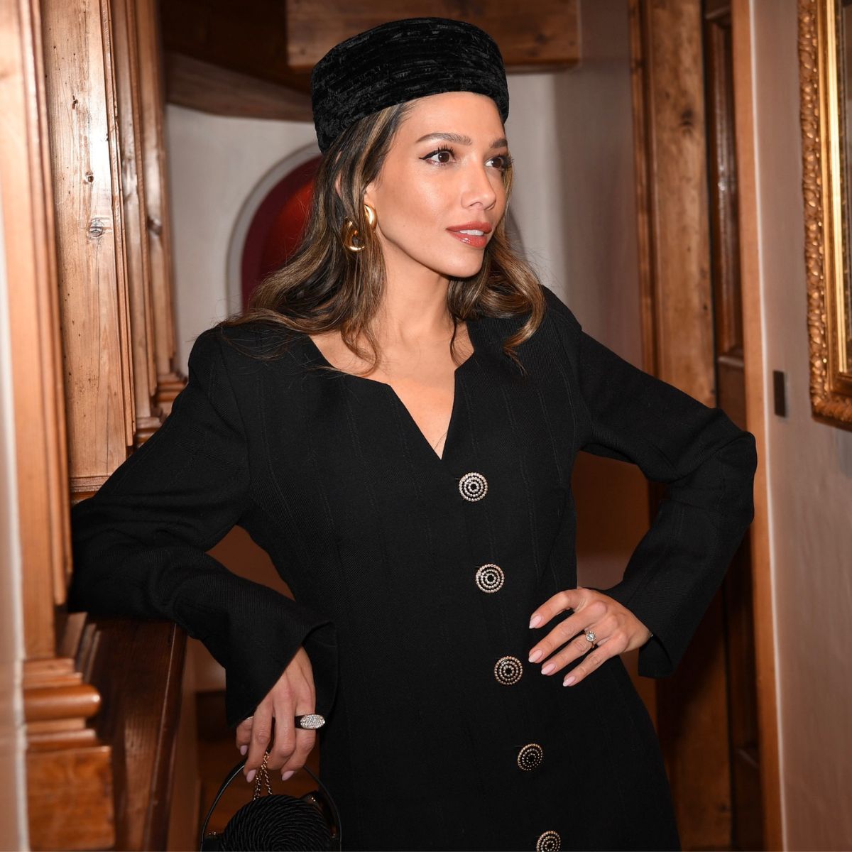 leila kashanipour wears a black pillbox hat and elegant jacket