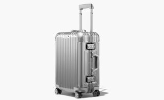 The design classic Original Cabin carry-on bag by Rimowa. Silver carry-on bag with wheels and a handle.