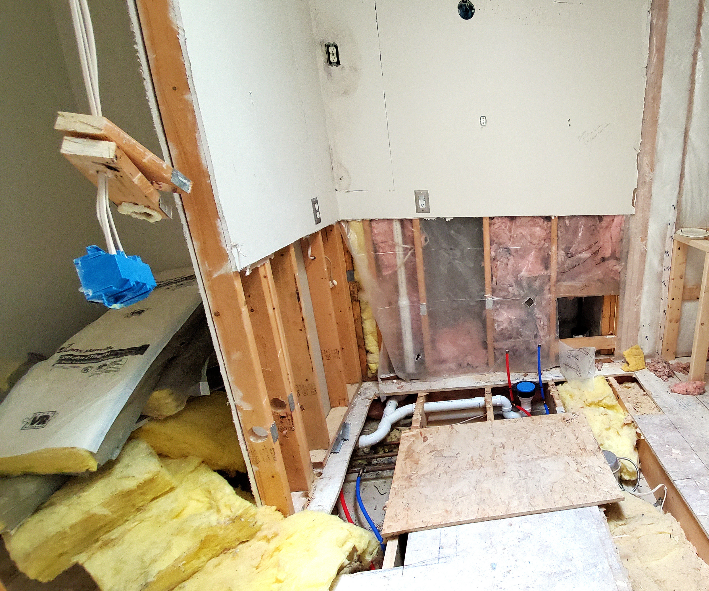 Room during a renovation with insulation on the floor and wall taken apart