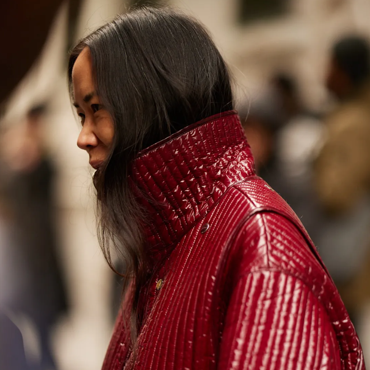 woman wearing a red high-collar jacket.