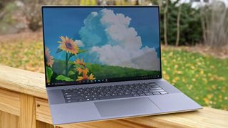 Dell XPS 17 9710 laptop on a wooden fence, displaying Windows 10 desktop