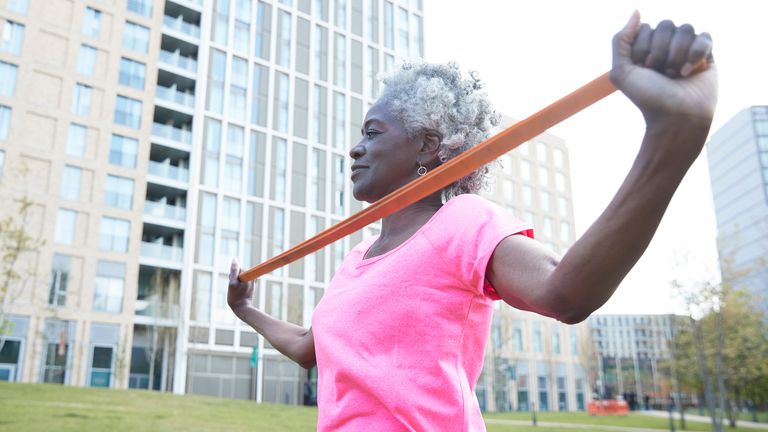 Senior woman strengthens her arms with a resistance band workout