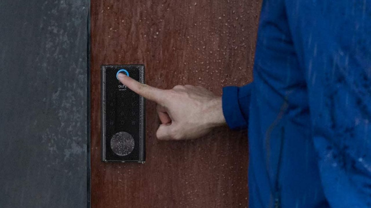 best smart lock: Eufy smart lock fingerprint sensor being pressed by man in the rain