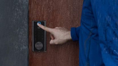best smart lock: Eufy smart lock fingerprint sensor being pressed by man in the rain