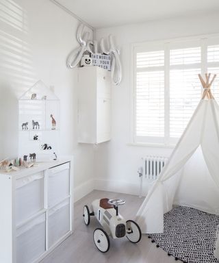 White kids' room ideas with a teepee, shelving and toy car.