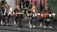 Megadeth performing with acoustic guitars on a street in 2024
