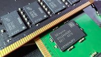 A close-up photo of a pair of Micron and SK Hynix DDR5 DIMMs, showing the memory modules on black/green PCBs