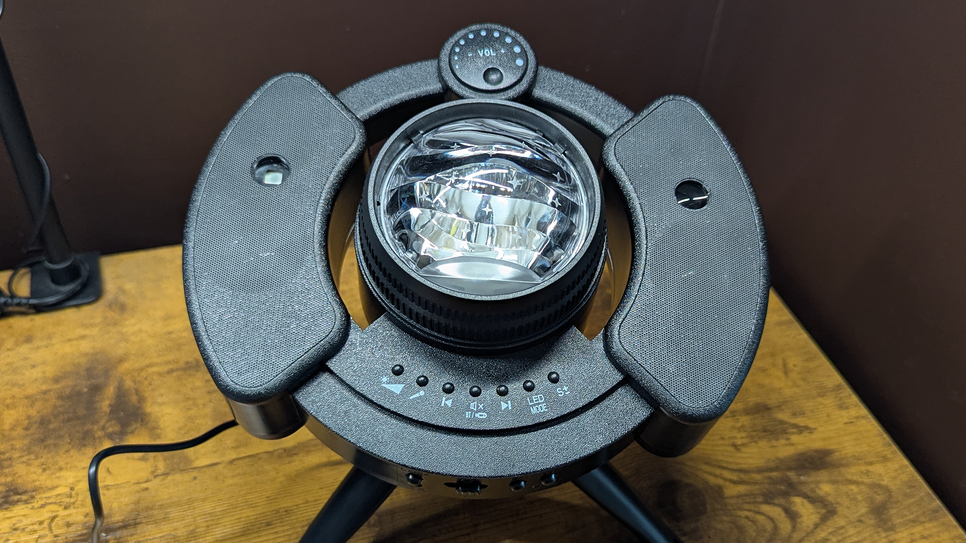 YgiTK Northern Galaxy Lights Projector during Review, on a wooden table against a dark coloured wall