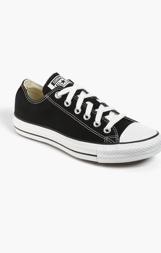 a pair of black converse chuck taylor sneakers in front of a plain backdrop