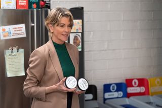 Wendie Malick as Dr. Julie Baram, holding two pints of ice cream while standing in an office kitchen, in 'Shrinking.'