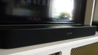 A Sonos Beam soundbar pictured below a TV