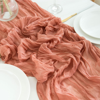 A muted coral table runner on a dining table, close up