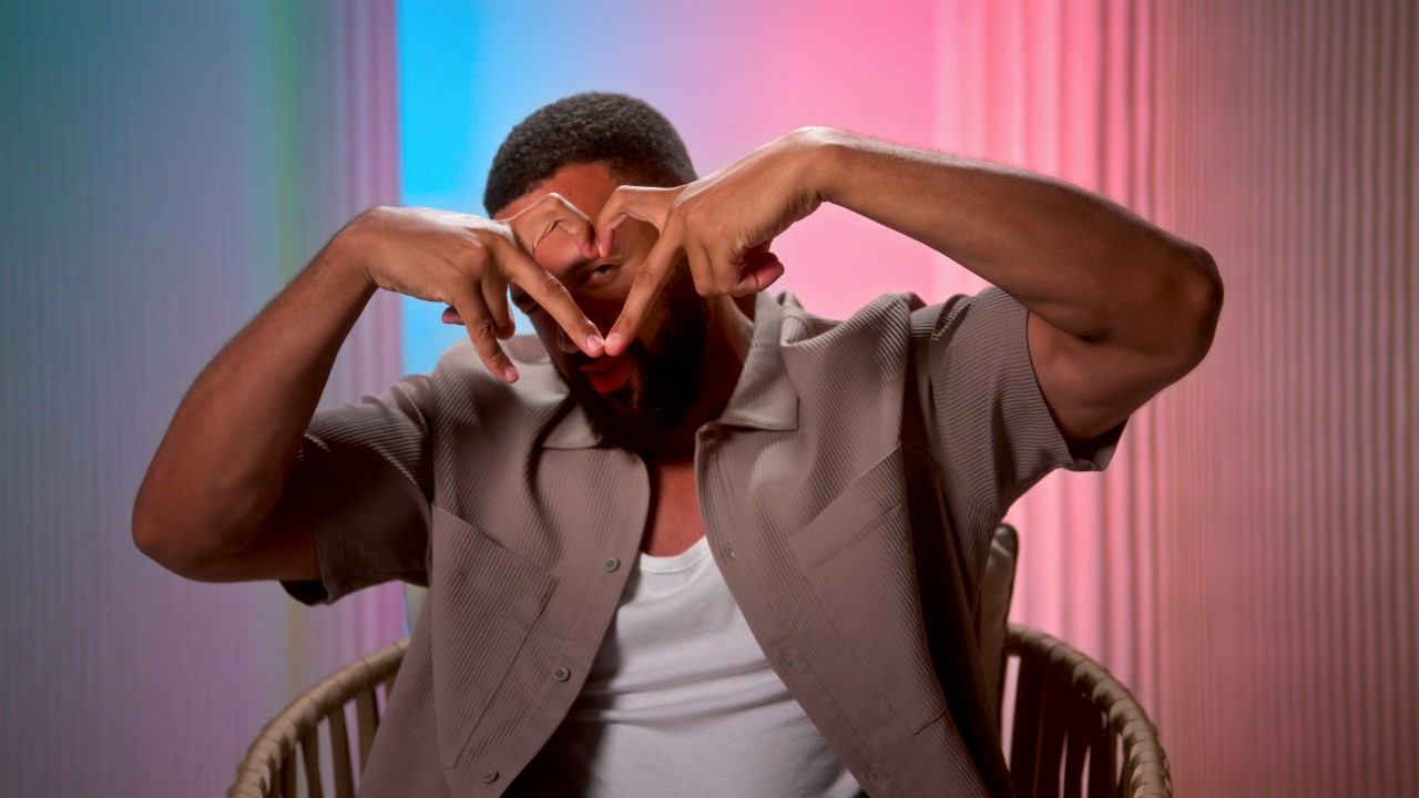 Ollie Sutherland makes heart fingers on Perfect Match Season 3.