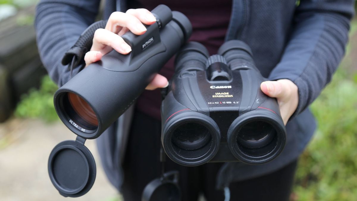 Someone holding a pair of binoculars and a monocular