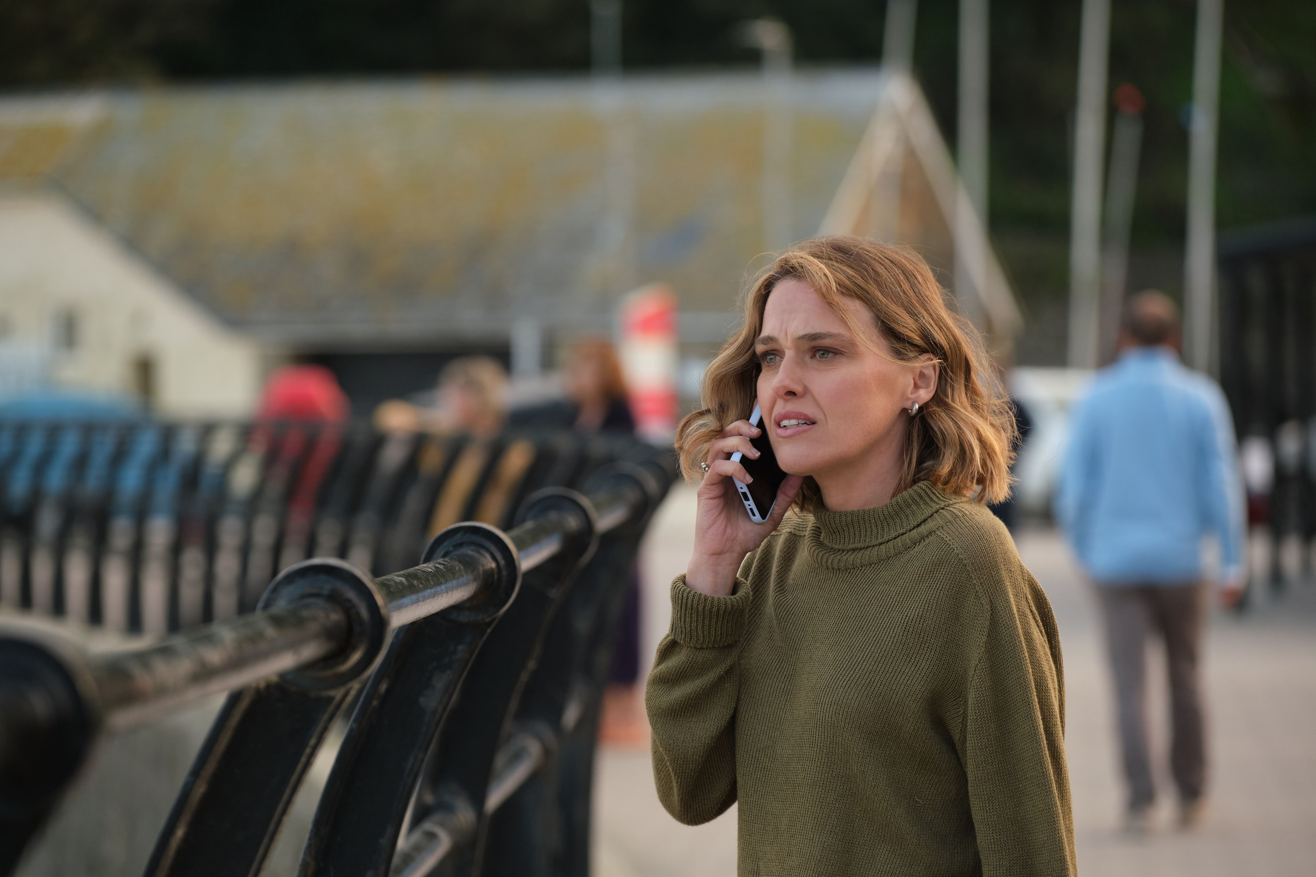 Martha (Sally Bretton) stands on the seafront, making a call on her mobile phone and looking distressed