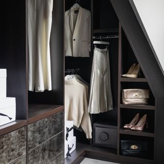 Dark brown walk in wardrobe in a bedroom corner