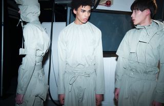 Three male models in white/grey boiler suits