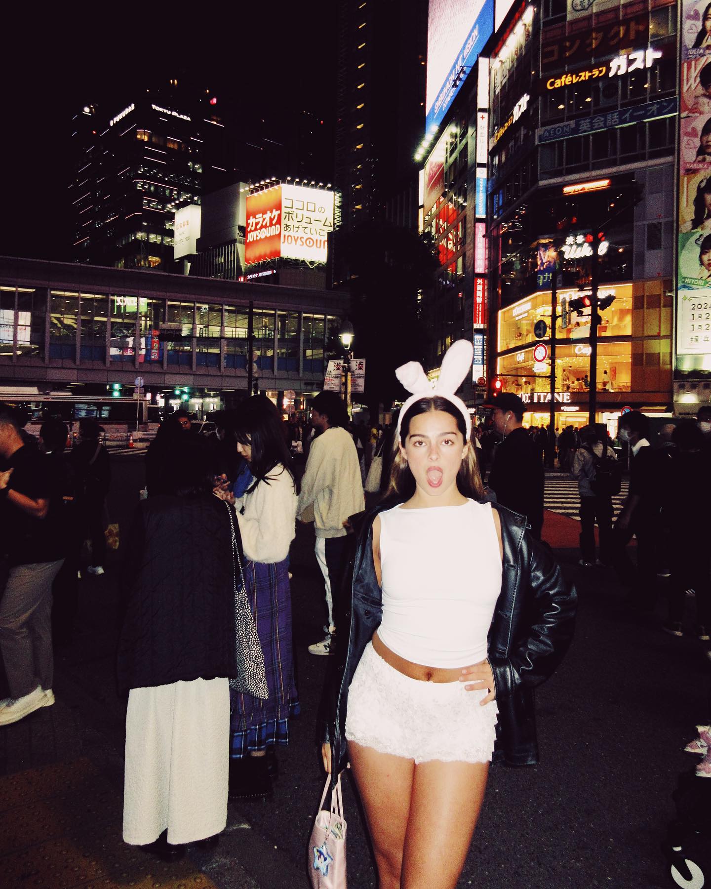 Gen Z woman wearing bloomers with jacket, glasses, and white tights.