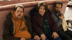 Guillaume Cyr, Margo Martindale, and Chris Diamantopoulos hide, bloodied, behind a couch in The Sticky