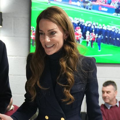 Kate Middleton wears a navy coat with gold buttons