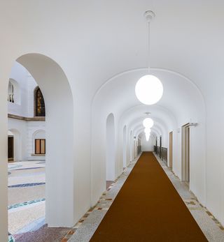 Arched corridors create sightlines through the building increasing openess and reducing the strict hierarchy of the previous design