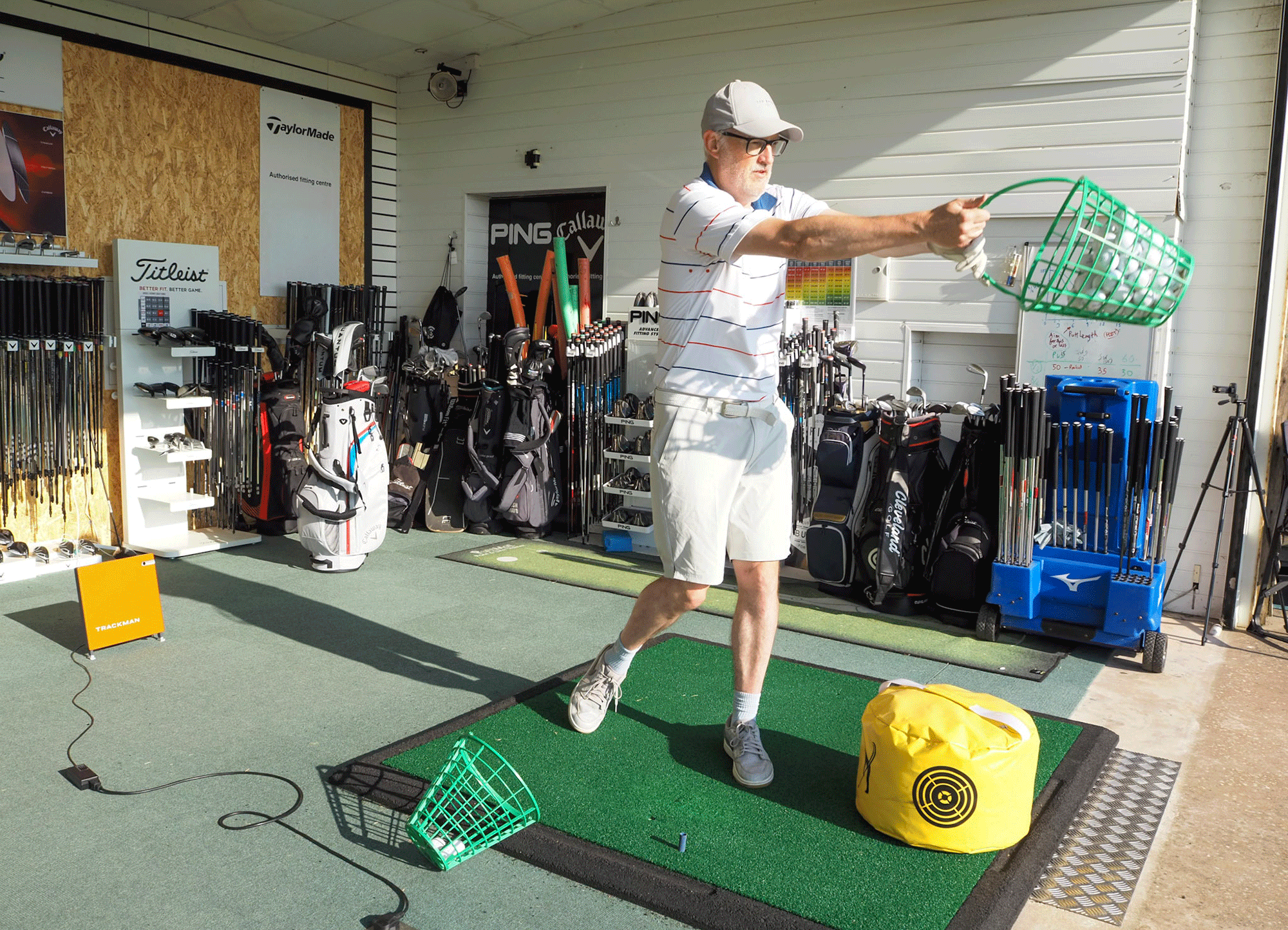 Rob Spedding swinging a bucket of range balls to improve his movement throughout the golf swing
