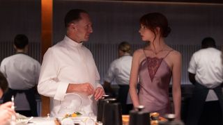 Ralph Fiennes and Anya Taylor-Joy standing together in The Menu