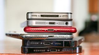 Various Apple iPhones stacked next to each other.