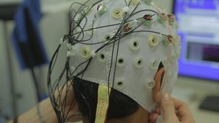 The exoskeleton worn by a paralyzed person will be controlled using EEG (electroencephalogram) signals recorded from a cap worn on the head.