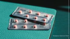 Packet of HRT medication in pill packets, sitting on leather folder to represent the pros and cons of HRT