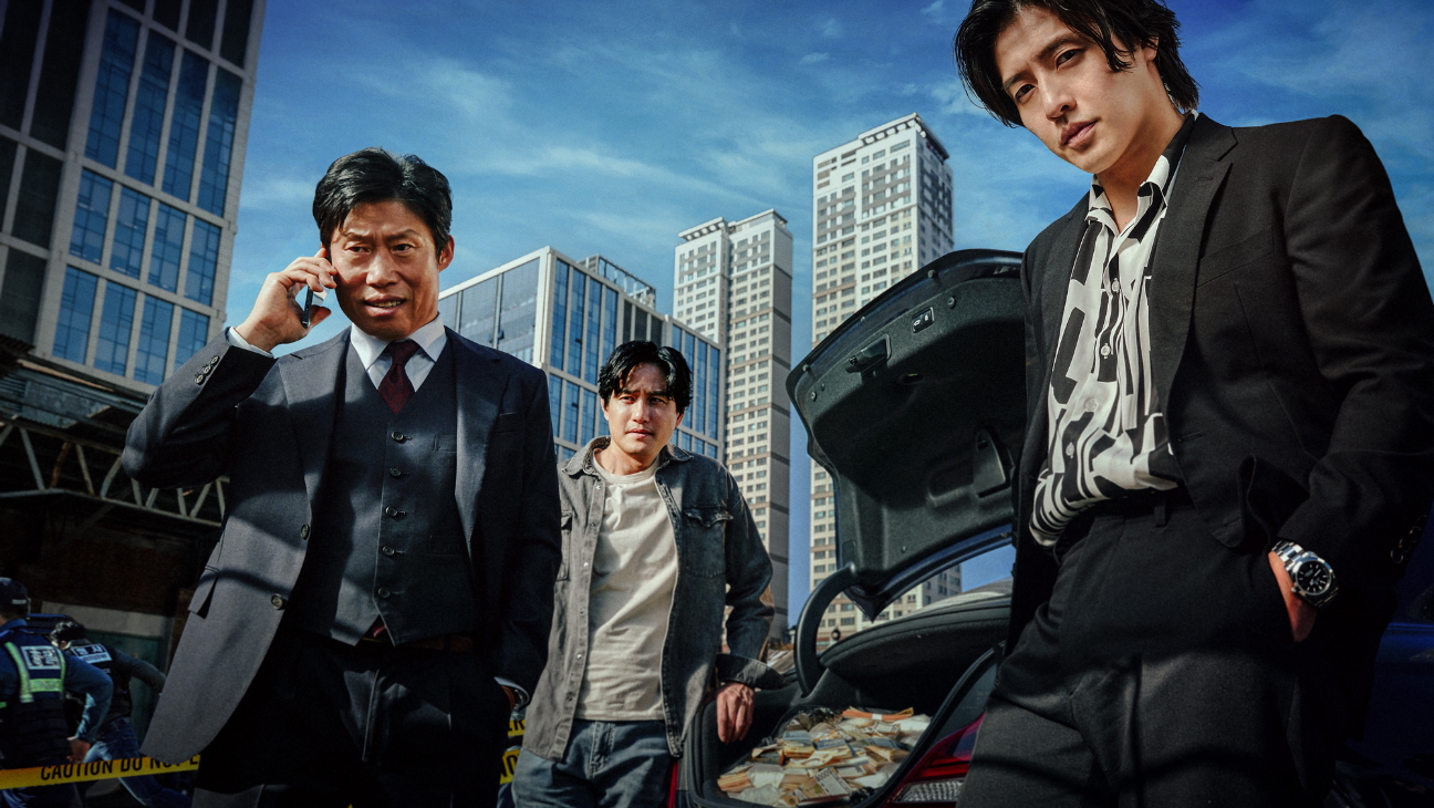 A prosecutor (Yoo Hae-jin) talks on a phone, as two men (Park Hae-joon and Kang Ha-neul) lean on a car trunk full of money, in the Korean movie 'Yadang: The Snitch.'