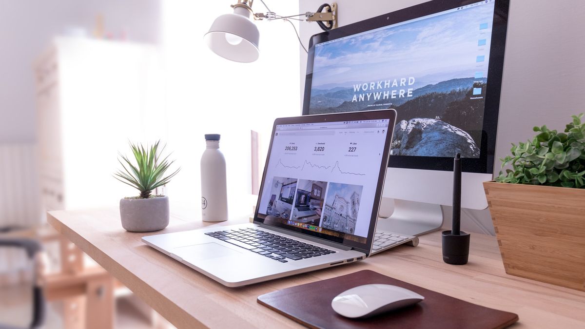 laptop and monitor on desk with websites open