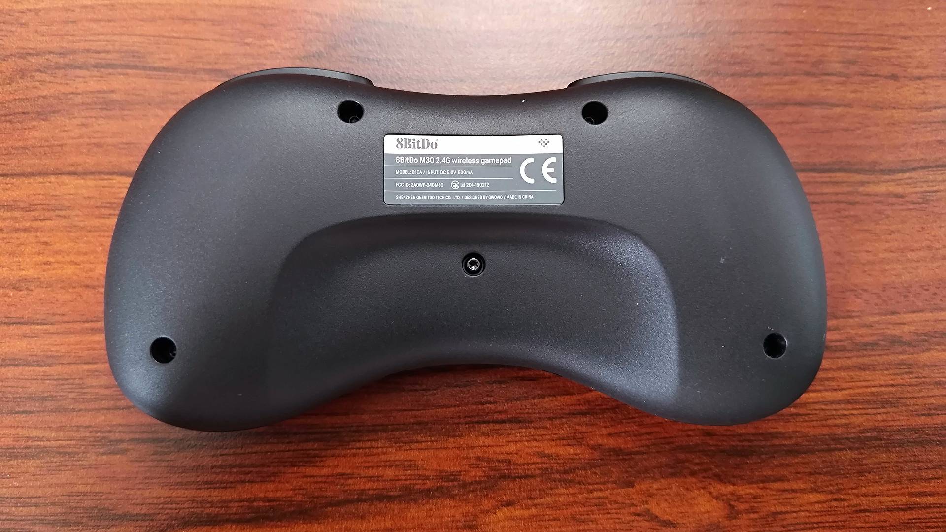 Back view of 8Bitdo M30 Sega Mega Drive/Genesis 23.4Ghz Wireless controller on woodgrain desk.