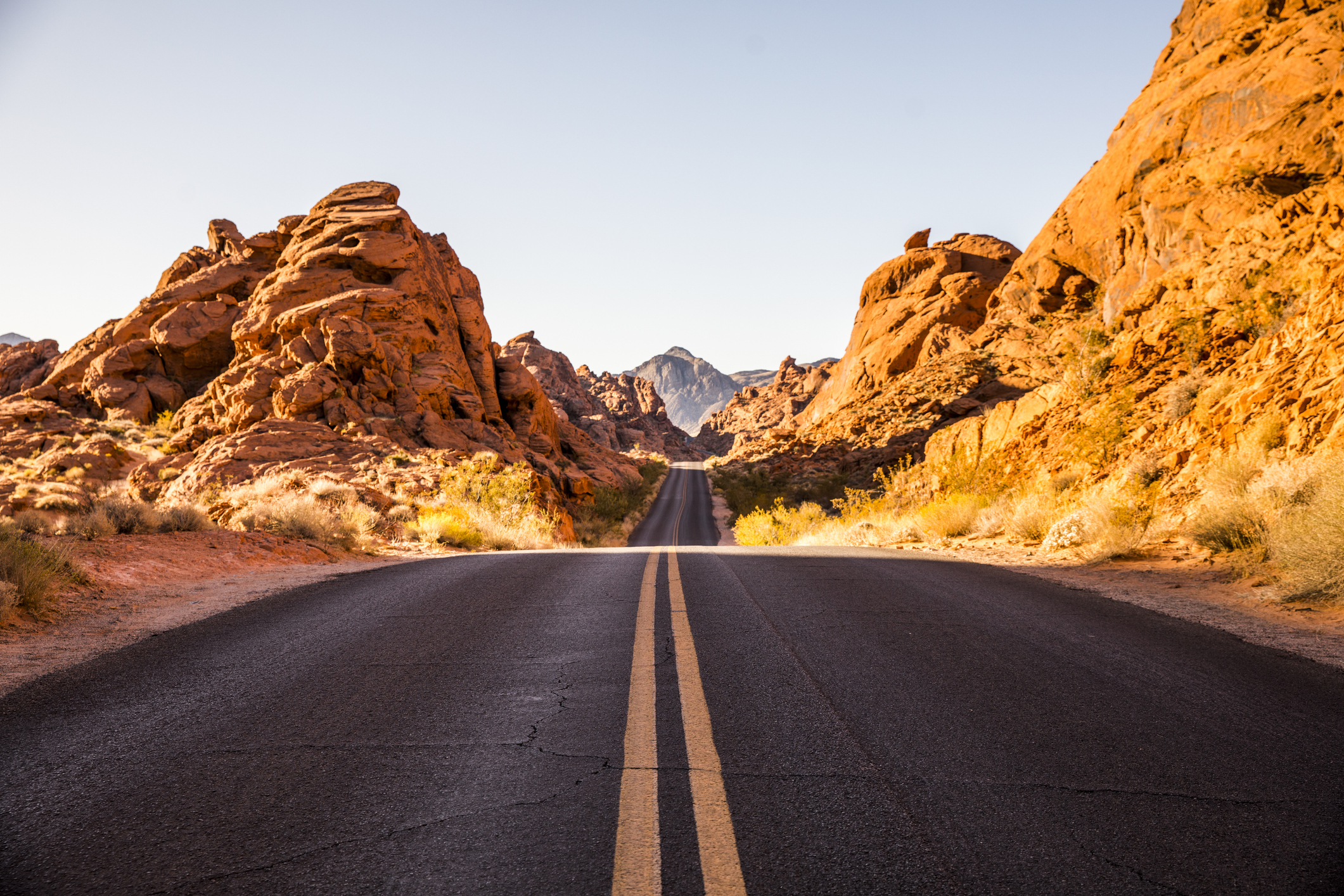 Scenic desert road in Nevada with red rocks on either side
