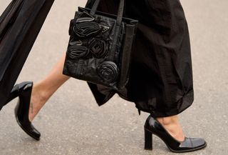 A woman wearing a long skirt and black pumps.