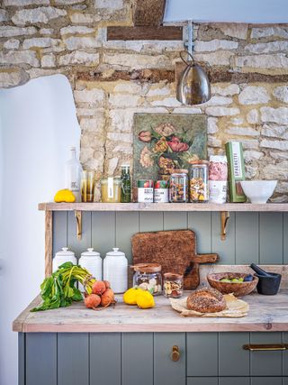 pantry with grey tongue and groove panelling with exposed stone wall and beams